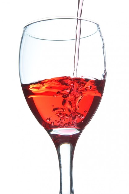 The wine pouring a drink into a glass. On a white wall.