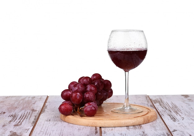 Wine pouring into glass with grape and bottles isolated