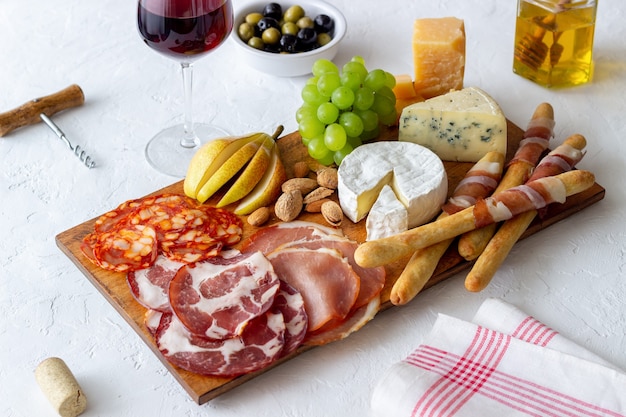 Photo wine snack. jamon, camembert, chorizo, almonds, blue cheese, parmesan. antipasti. wine appetizer.