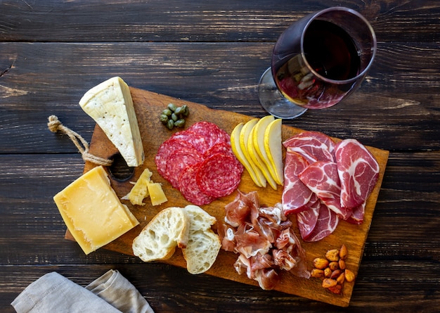 Merenda al vino. prosciutto di parma, prosciutto di parma, salame, mandorle, olive, baguette, gorgonzola, parmigiano. antipasti.