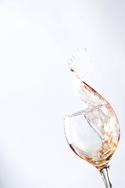 Photo wine spilling out from glass against white background