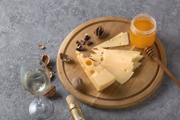 wine tasting concept with traditional appetizers of cheese, nuts and honey. food and drink