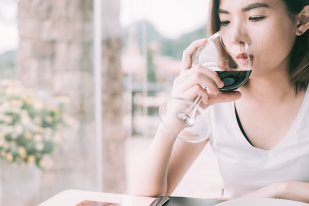 Wine tasting tourist woman.Young Woman drinking wine in Italian style restaurant