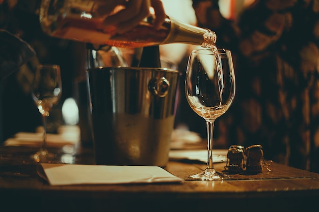  wine tasting: on a wooden table there are silver buckets for cooling wines with bottles of champagne