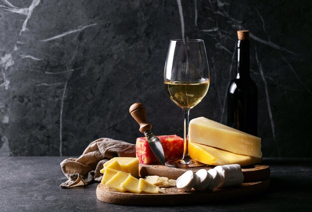 Photo wine with cheese on table against wall