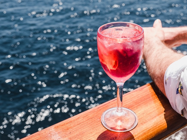 Wineglass with a pink cocktail and ice cubes