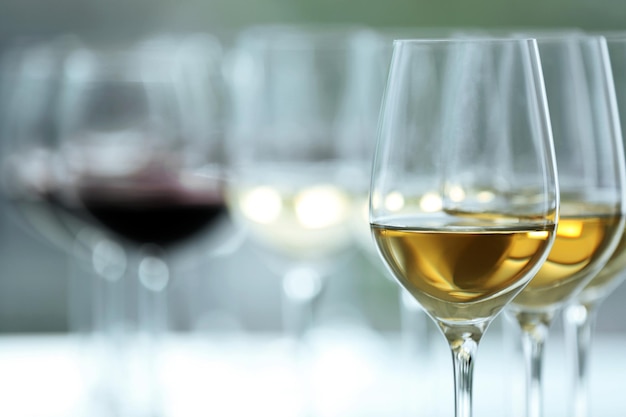 밝은 배경의 나무 테이블에 흰색과 빨간색 와인이 있는 와인잔