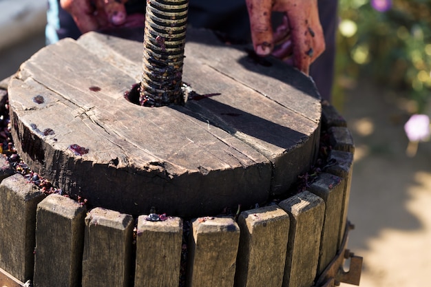 赤いマストとらせんネジを備えたワインプレス。伝統的なイタリアワインの生産、ブドウの粉砕。