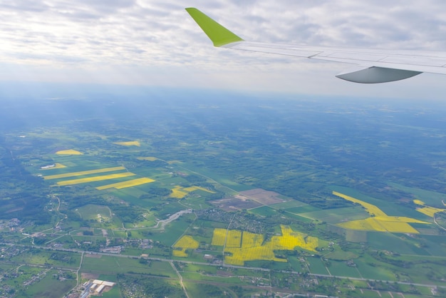 Photo the wing of an airborne aircraft over land and water sunny weather beautiful view