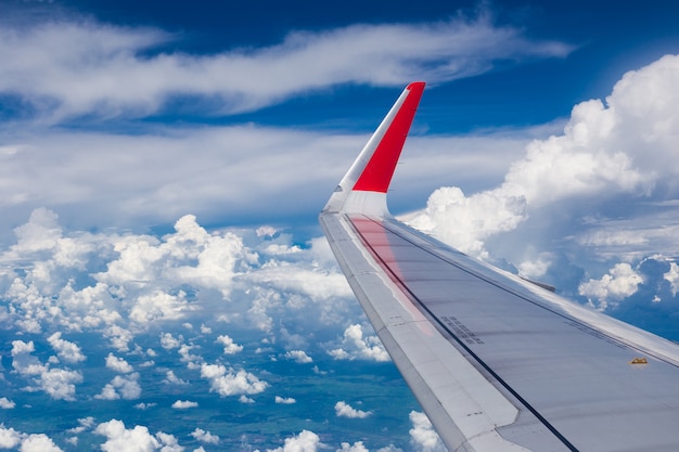 Wing of an airplane against cloud and blue sky