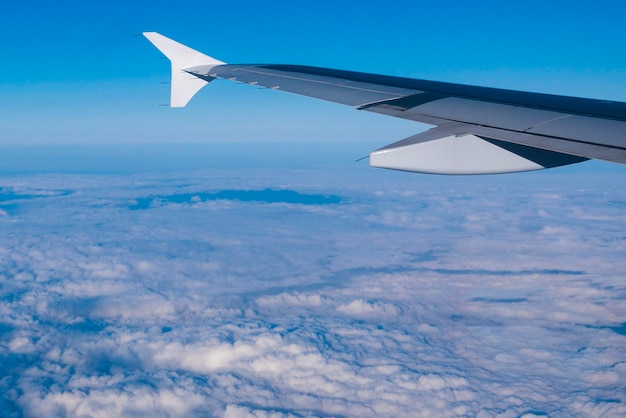 Wing of an airplane flying above the clouds