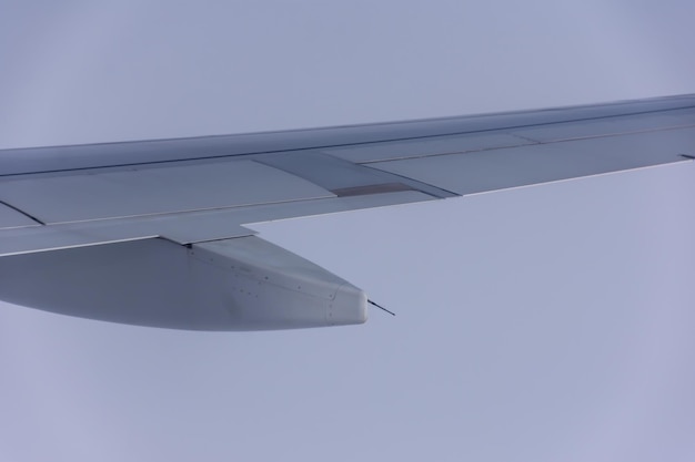 The wing of an airplane flying in the sky