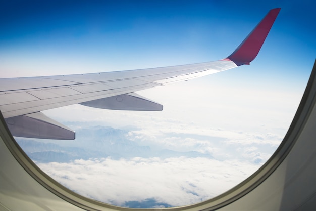 Wing of an airplane flying above sky