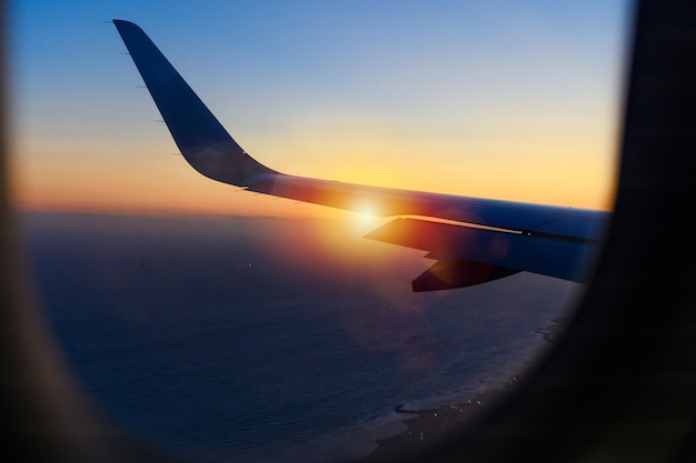 Wing of a airplane in the sky during a sunset