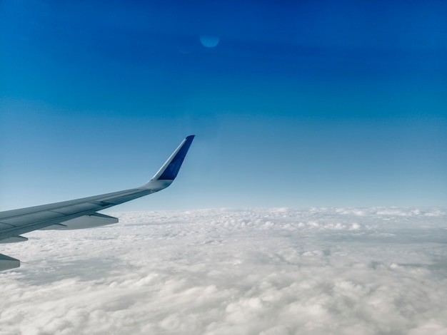 白い雲の上の飛行機の翼