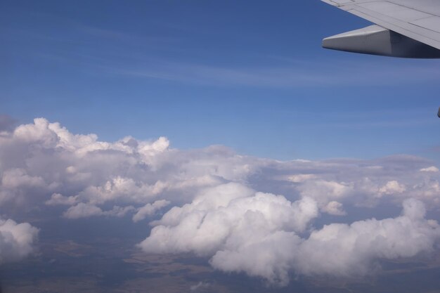 The wing of a flying aircraft against the background of clouds