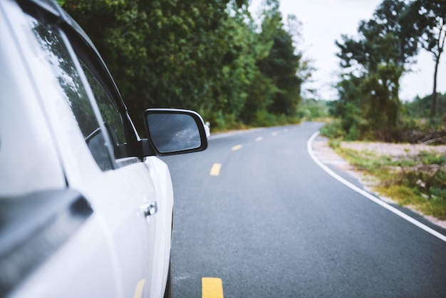 The wing mirror of a Car with nature street.