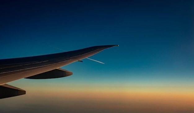 Foto ala di un aereo sopra la città aereo che vola sul cielo blu vista panoramica dalla finestra dell'aereo