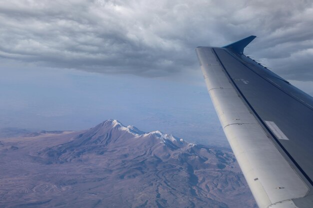 A wing of a plane is visible from the window of a plane