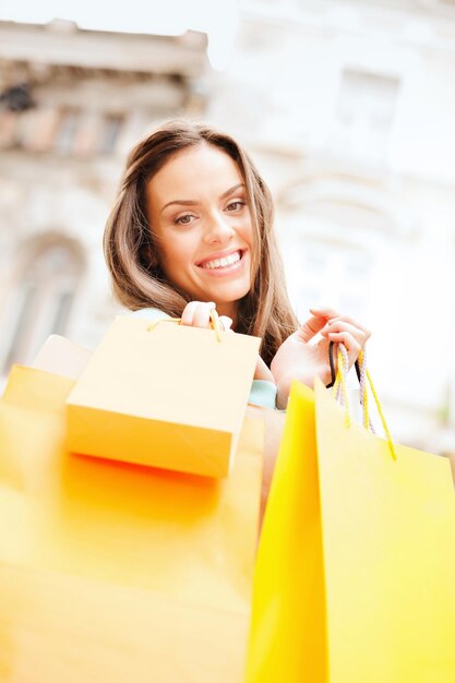 winkel- en toerismeconcept - mooie vrouw met boodschappentassen in ctiy