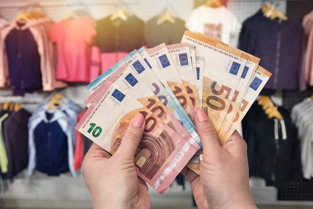 Winkelconcept in kledingwinkel met euro in handen