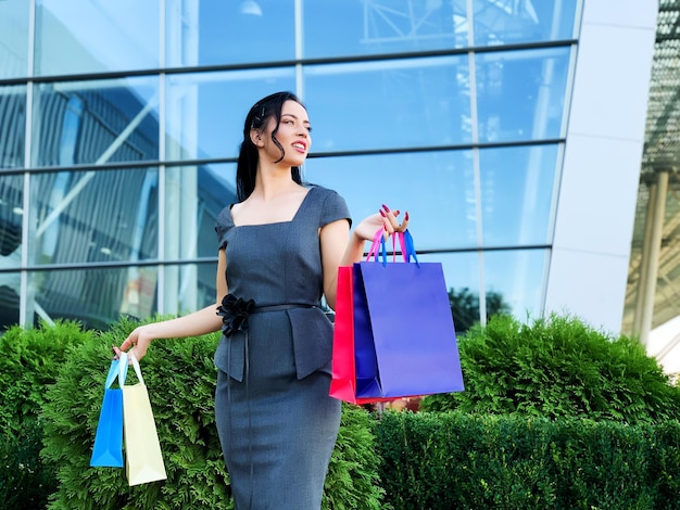 Winkeldag Vrouw met gekleurde tassen in de buurt van haar winkelcentrum in zwarte vrijdagvakantie