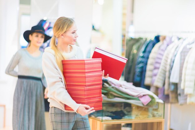 Winkelen Het meisje houdt dozen met schoenen vast