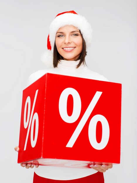 winkelen, verkoop, geschenken, kerstmis, x-mas concept - glimlachende vrouw in santa helper hoed met procentteken