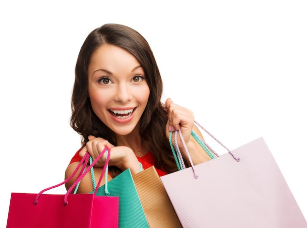 winkelen, verkoop, geschenken, kerstmis, x-mas concept - lachende vrouw in rode jurk met boodschappentassen