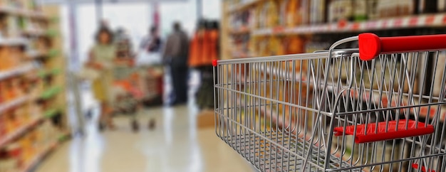 Winkelkarretje leeg met rood handvat op onduidelijk beeldsupermarkt 3d illustratie als achtergrond