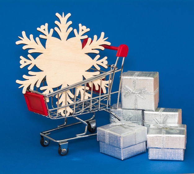 Winkelmandje en sneeuwvlok in Zilverkleurige geschenken Creatief concept over seizoenskortingen