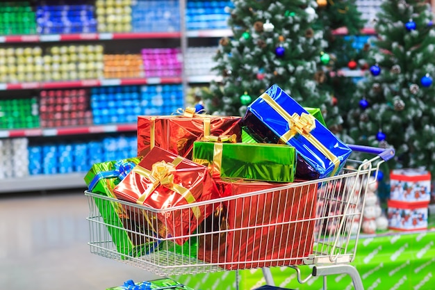 Winkelwagen met geschenken op de achtergrond van de supermarkt