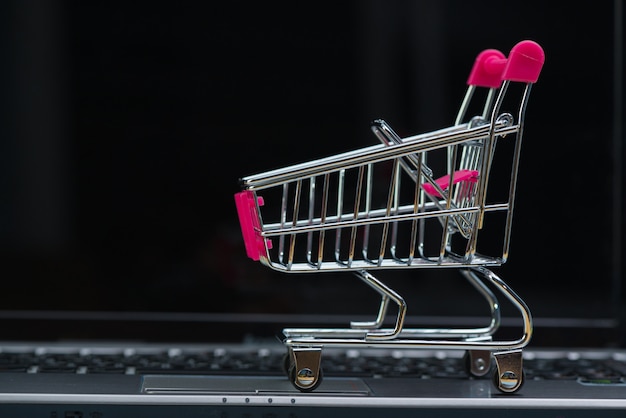 Winkelwagen of supermarkt trolley met laptop notebook, e-commerce en online winkelen concept.