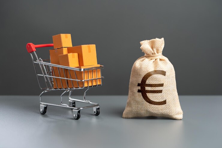 Foto winkelwagentje met dozen met goederen en euro-geldzak koopkracht van kopers handel en detailhandel belastingen en inkomen consumptieprijzen invoer van producten