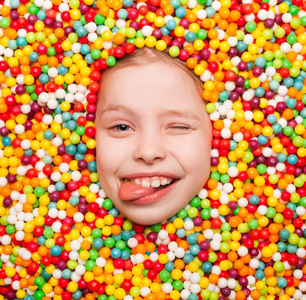 Winking boy lying in candies