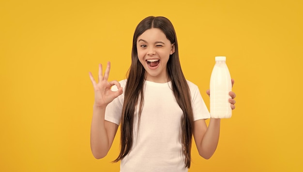 Winking child hold dairy beverage product teen girl going to drink milk