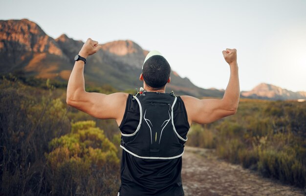 Winnaar berg en runner man succes met achteraanzicht vieren cardio oefening doel overwinning Gespierd sterk en fitness levensstijl mannelijke hardloopprestatie viering in Zuid-Afrikaanse bush