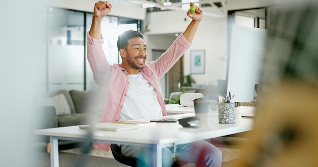 Foto winnaar wauw en juichen met een zakenman die een doel of doel bereikt in zijn kantoor op het werk motivatiedoelen en succes met een mannelijke werknemer ter ere van een deal of promotie tijdens het werk