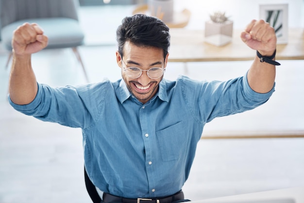 Foto winnaarsucces en gelukkige zakenman op kantoor vieren en opgewonden voor e-mailbeoordeling of goedkeuring van lening handenviering en zakelijke mannelijke online winnaar met emoji wow of winnend gebaar