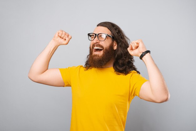 Winner bearded man is celebrating victory and gesturing Studio shot