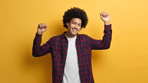 Winner cheerful african american young man dancing over yellow background