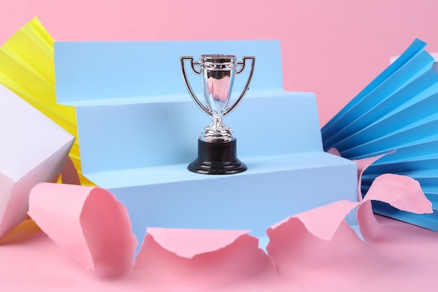 사진 기하학적 모양이 있는 분홍색 배경의 우승자 컵 미니멀리즘 컨셉 아트