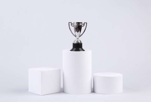 Winner cup on a pedestal of geometric shapes on a white background