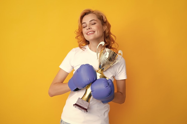 Winner female boxer isolated on yellow background winning success power woman concept happy