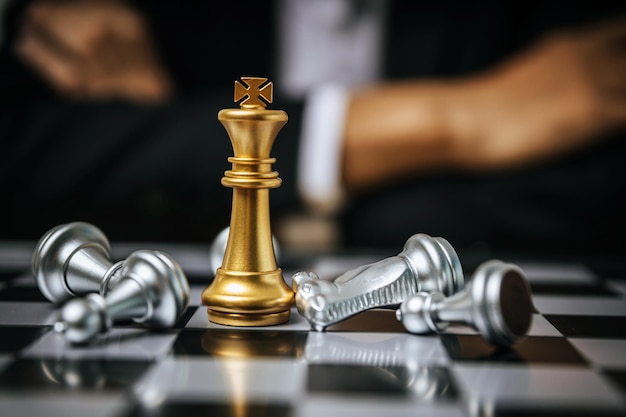 Winner. golden king with silver chess piece on chess board game competition on business man background, checkmate, chess battle, victory, success, team leader, teamwork, business strategy concept