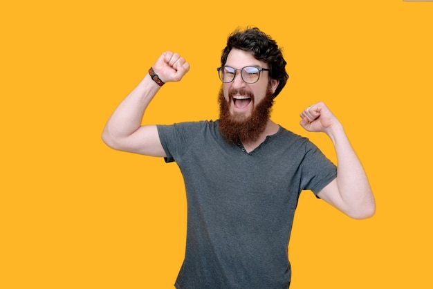 Winner guy, photo of beaded man celebrating with rised hands, on yellow