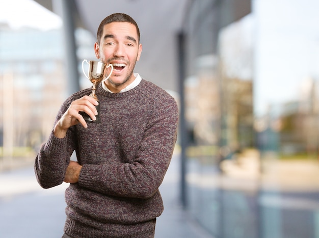 Winner young man holding a gold cup