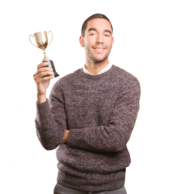 Photo winner young man holding a gold cup