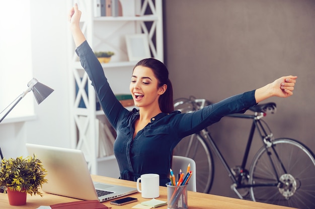 Winning every day. Attractive young woman stretching out hands and looking excited