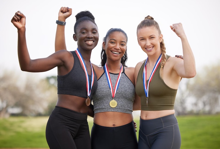 Photo winning gold is every athletes dream. cropped portrait of three attractive young female athletes celebrating their victory.